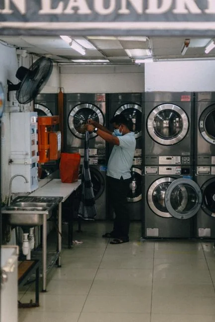 Un employé en tenue de protection désinfecte une cuisine, afin d’assurer un environnement propre et sûr.